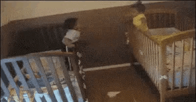 two babies are playing in a crib in a room