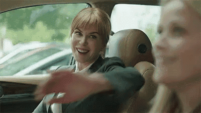 a woman is sitting in the back seat of a car with her arm outstretched .
