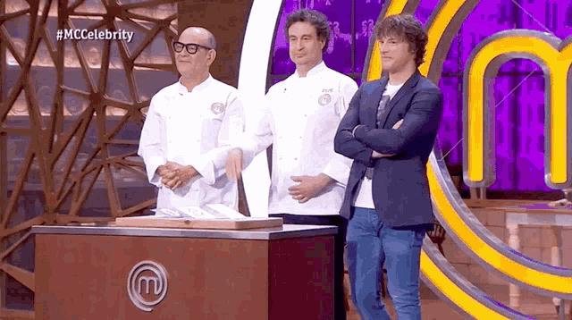 three men stand in front of a mc celebrity logo