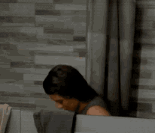 a woman is sitting in a bathtub with a towel on her shoulder