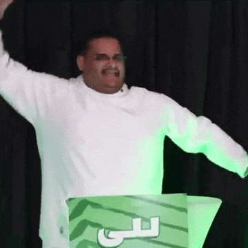 a man in a white shirt is standing behind a green podium with the letter f on it