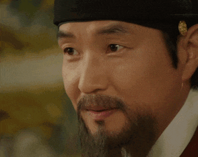 a man with a beard is wearing a black hat and a red shirt