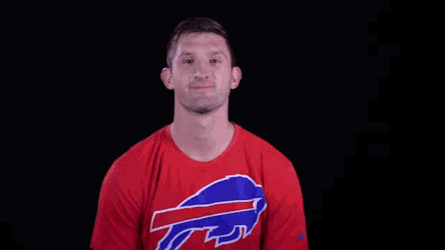 a man wearing a red shirt with the bills logo on it
