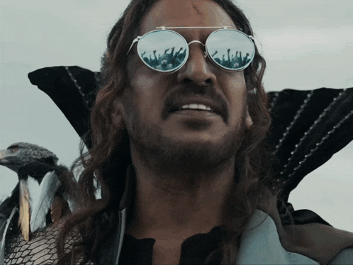 a man with long hair wearing sunglasses and a snake