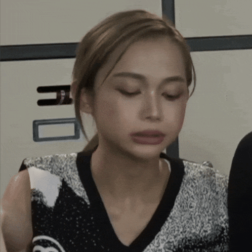 a woman with her eyes closed is wearing a black and white shirt
