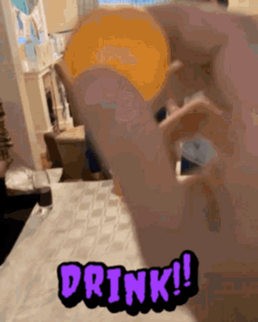 a person is holding an orange in their hand with the words drink written on it