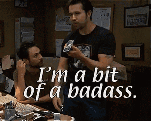 a man holding a cell phone with the words i 'm a bit of a badass