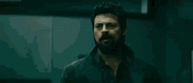 a man with a beard is standing in a dark room with a caption that says sounds like you got .