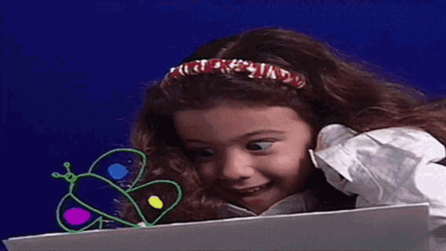 a little girl is smiling in front of a blue background that says estamos presentando