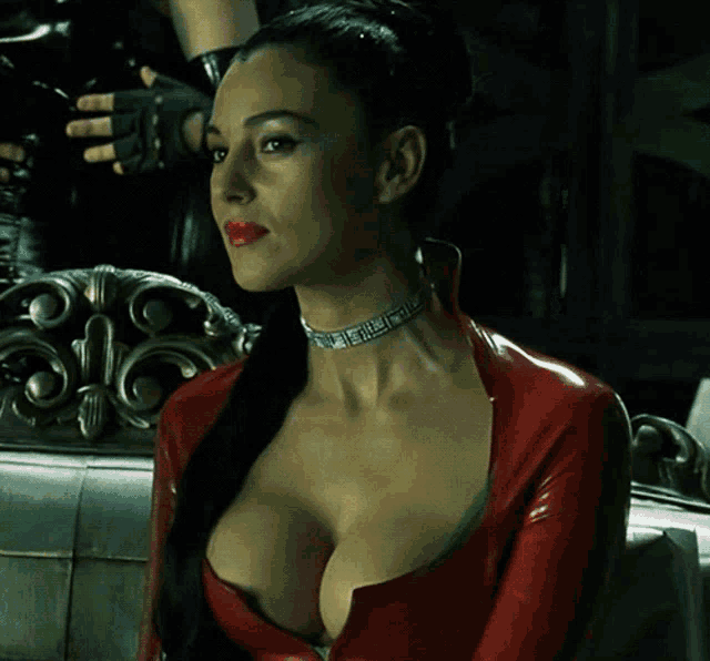 a woman with a choker around her neck is wearing a red latex jacket