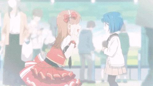 a girl in a red dress is talking to a girl in a blue shirt