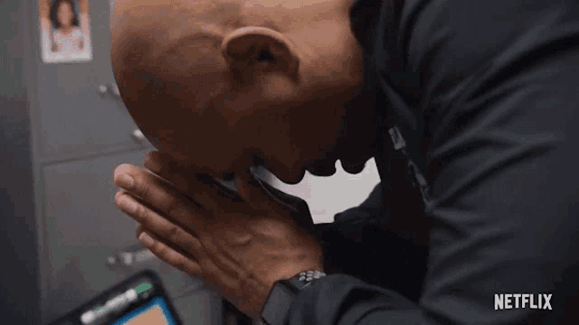 a man with his head in his hands and a netflix logo in the corner