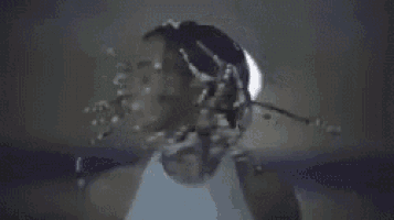 a close up of a person 's face with a light shining on it in a dark room .