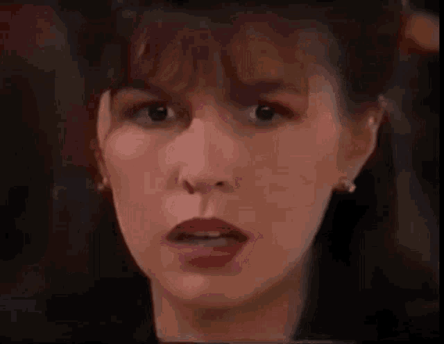 a close up of a woman 's face with a surprised expression on her face .