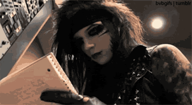 a person with a tattoo on their arm is holding a notebook