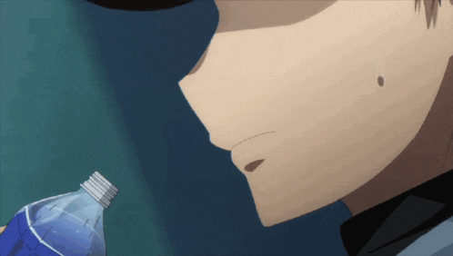 a close up of a person holding a bottle of blue water