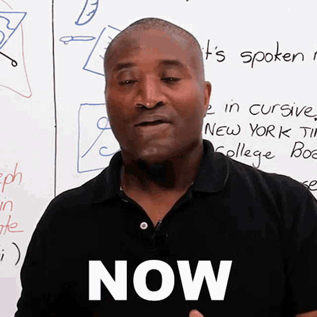 a man is standing in front of a white board with the word now on it