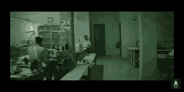 a man is walking through a dark room with a lot of tables .