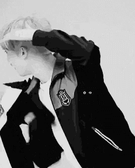 a black and white photo of a person wearing a jacket with a badge that says ed on it .