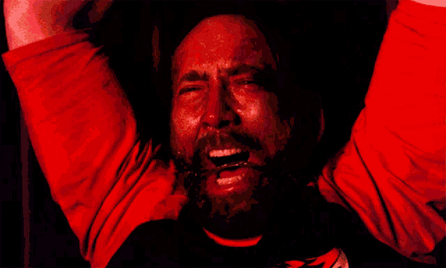 a man with a red shirt on is crying