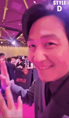 a man is smiling in front of a sign that says netflix on it