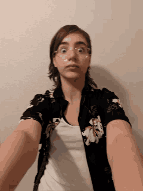 a young woman wearing glasses and a floral shirt