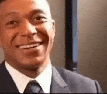 a man in a suit and tie is smiling for the camera .