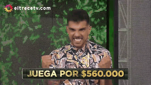 a man stands in front of a screen that says juega por $ 560000