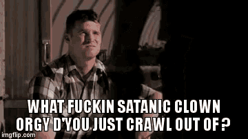 a man in a plaid shirt is sitting in a dark room and talking to someone .