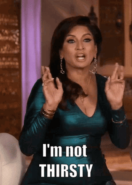 a woman in a green dress says i 'm not thirsty with her hands crossed