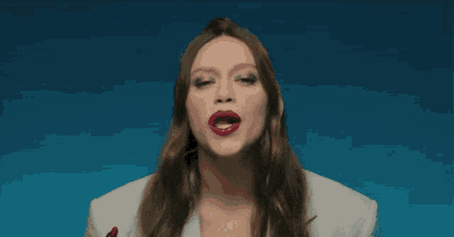a woman with red lipstick is wearing a white suit