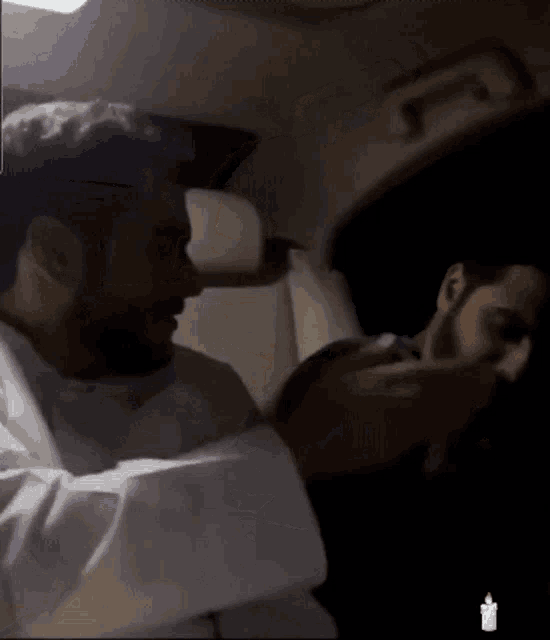 a man in a white shirt is holding another man 's hand
