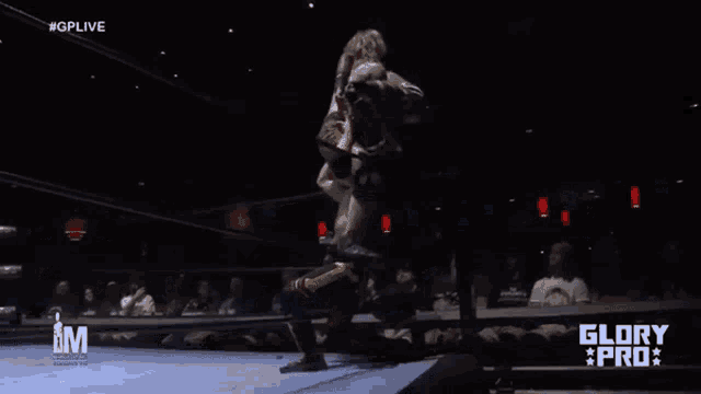a wrestling match is being shown on a television screen .