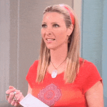 a woman wearing a red shirt and a headband is smiling