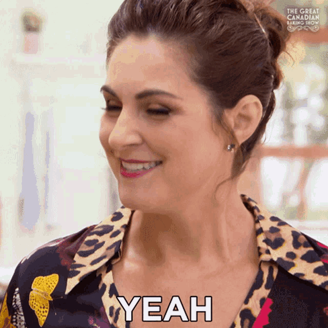 a woman in a leopard print shirt is smiling and says yeah