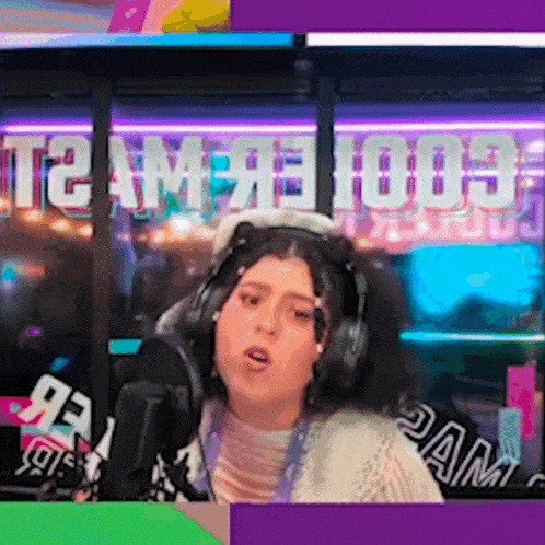 a woman wearing headphones stands in front of a microphone in front of a sign that says t2 amf 1003
