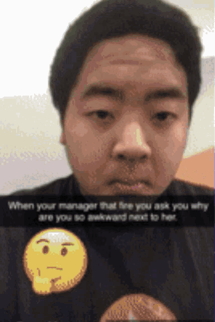 a man is wearing a black shirt with a yellow smiley face on it .