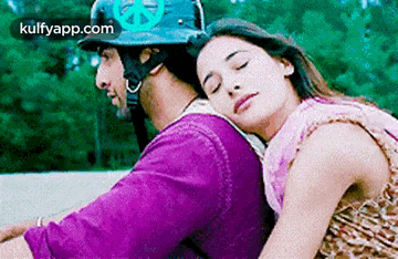 a man and a woman are sitting next to each other on a motorcycle . the woman is wearing a helmet .