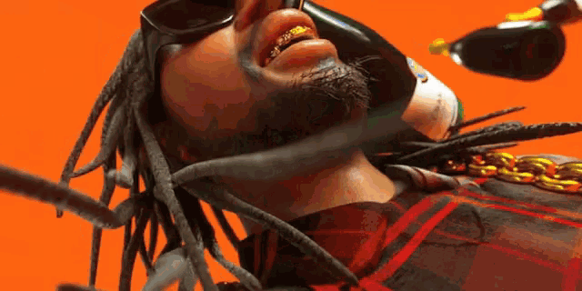 a man with dreadlocks and gold teeth is holding a bottle of champagne