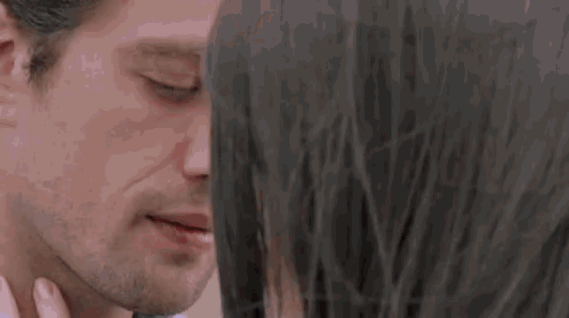a close up of a woman 's face with a man 's face behind her
