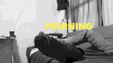 a black and white photo of a person laying on a couch with the word morning in yellow letters