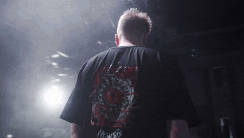 a man wearing a black shirt that says genesis on the back