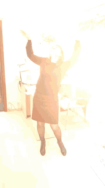 a woman with her arms outstretched in a room with a picture of a horse on the wall