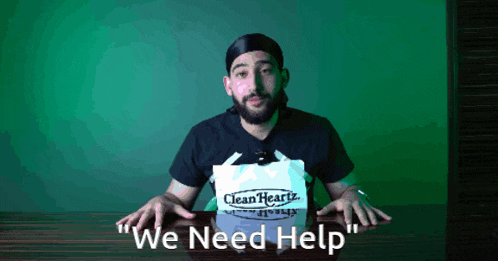 a man sitting at a table with a sign that says clean hearts on it