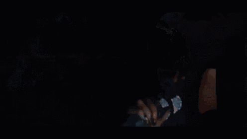 a woman is singing into a microphone in the dark .