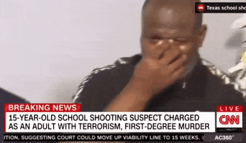 a man covering his face with his hand on a cnn news report