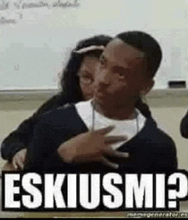 a man and a woman are hugging each other in a classroom and the man is holding the woman 's chest .