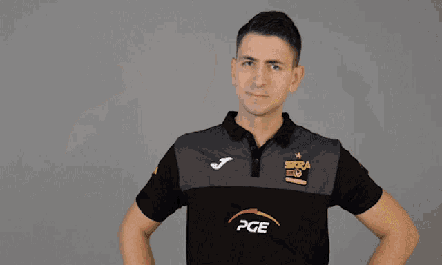 a man wearing a black shirt that says pge on the front