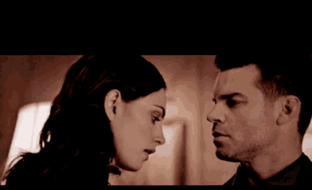 a man and a woman are looking at each other in a room .