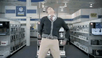 a man is dancing in a store with a sign that says best buy in the background